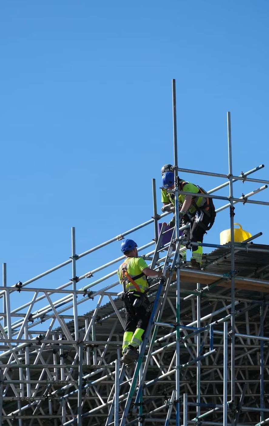 Workers on scaffolding around a building frame